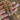 Close view of antique gold CZ floral bangles held by a jewelry model