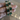 Emerald green cushion stone CZ bangles held by a jewelry model