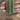 Emerald green oval statement bangles held by a jewelry model