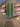 Emerald green oval statement bangles held by a jewelry model