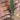 Set of four slim emerald green CZ bangles held by a jewelry model