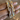 Angled view of pastel stone mirror-square bangles held by a jewelry model