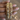 Gold jali kundan bangles with ruby and emerald stones held by a jewelry model
