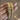 Gold jali kundan bangles with pearl white stones held by a jewelry model