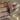 Ruby baguette bangles with emerald oval accents held by a jewelry model