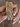 Baguette mosaic CZ bangles in gold tone held by a jewelry model