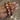 Red meenakari kundan bangles with pearl flowers held by a jewelry model