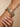Model wearing gold mirror-square pastel stone bangles on her wrist