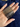 Stack of slim gunmetal-tone textured metal bangles held in hand