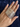 Stack of slim silver-tone textured metal bangles held in hand
