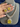 Yellow doublet CZ necklace with matching square halo stud earrings held beside the stand