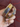 Angled view of Jaya multicolor meenakari enamel bangles showing gold floral patterns and crystal-studded edges