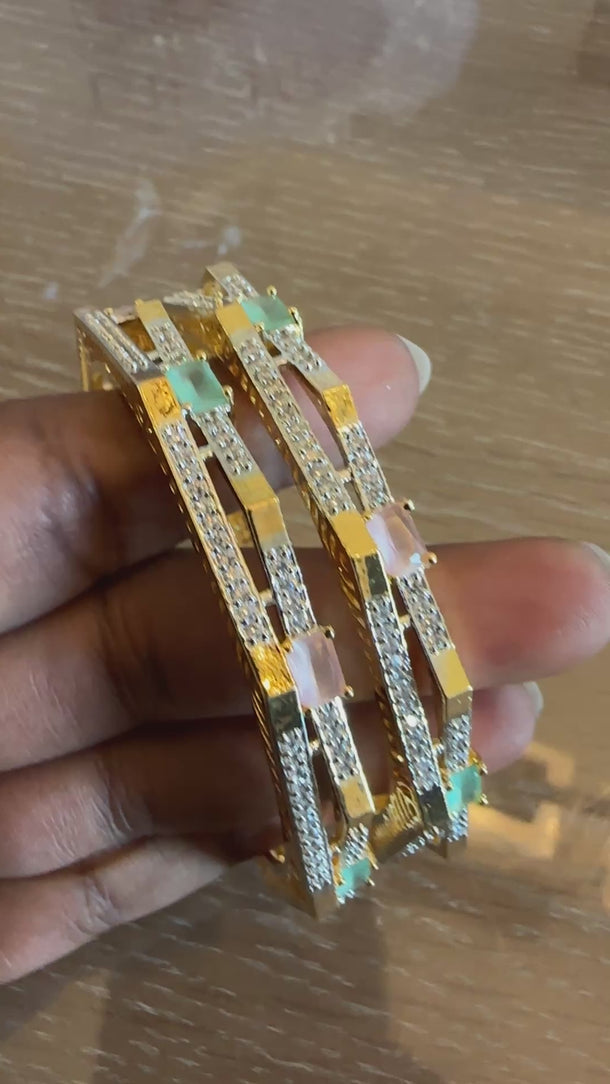 Video of gold mirror-square bangles with pastel stones turning in the light