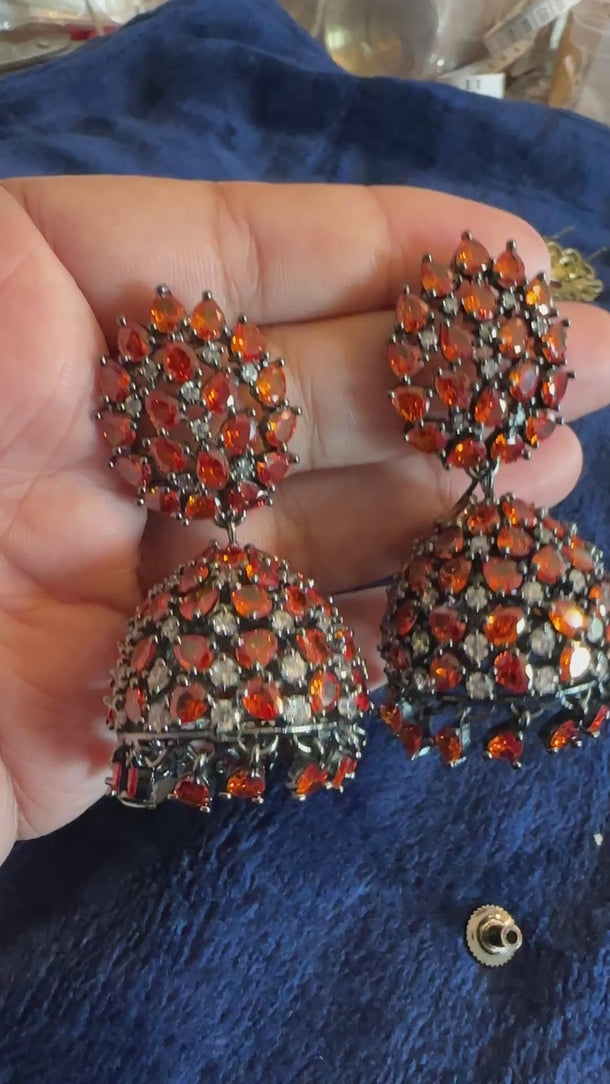 Video of orange crystal Victorian jhumka earrings with soft background music